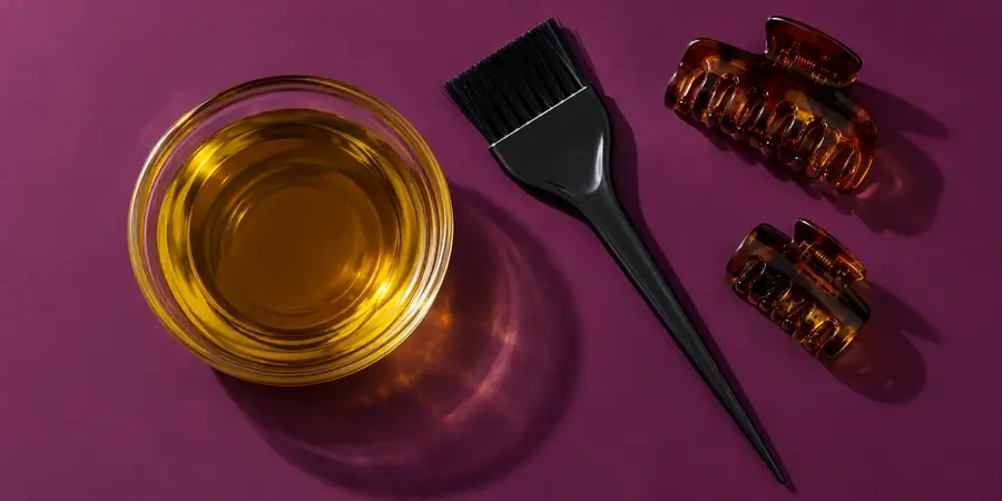 Bol d’huile de nigelle, pinceau applicateur et pinces à cheveux